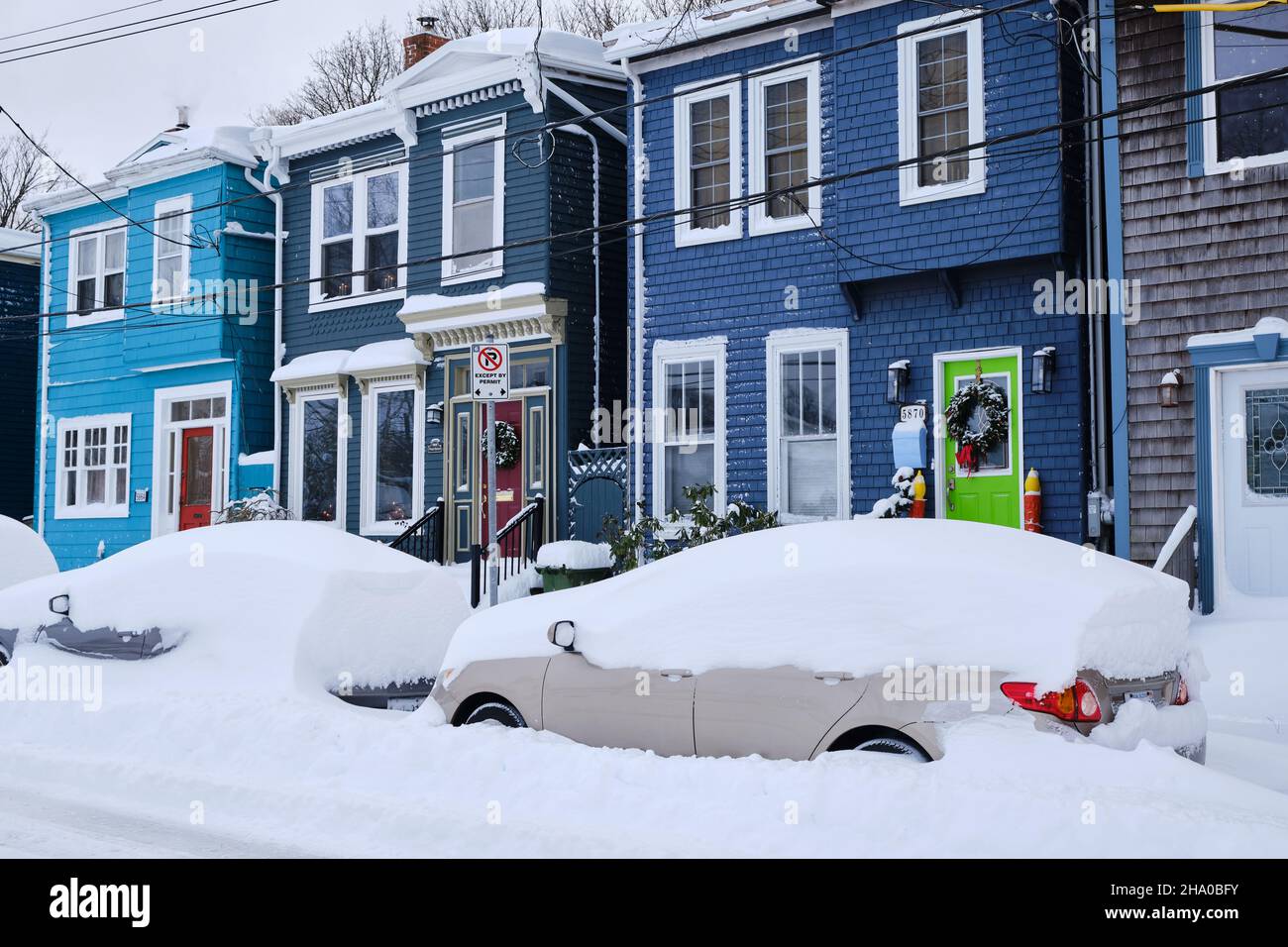 Halifax, Kanada, bedeckt mit Schnee nach dem ersten Schneesturm der Saison. Typischer Halifax Commons-Bereich mit buntem Haus auf der Straße mit Autos, die im Schnee begraben sind Stockfoto