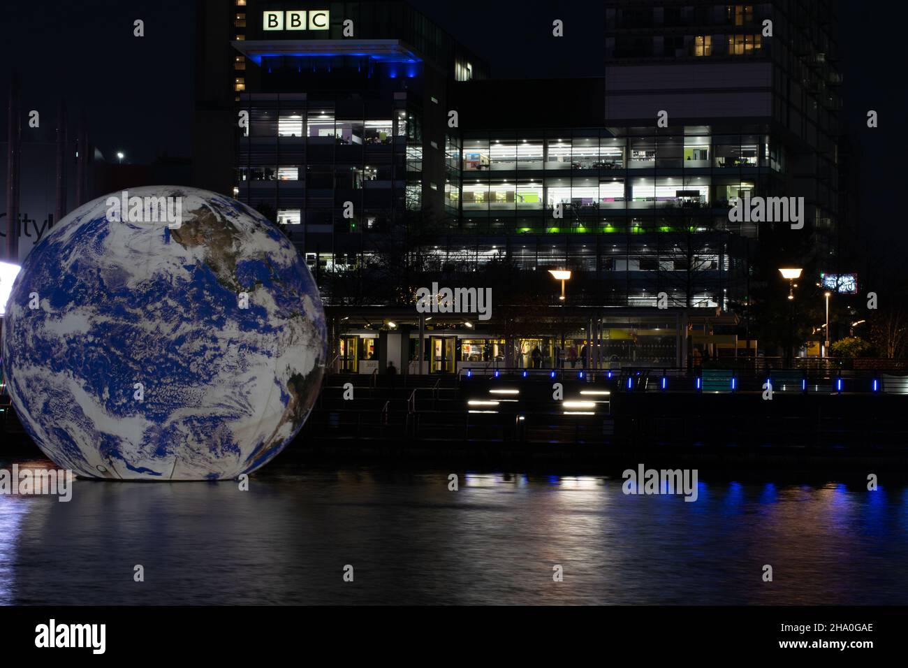 Media City Lightwaves Event mit Floating Globe Installation im Salford Quays BBC Gebäude mit Metrolink Straßenbahn. Langzeitbelichtung. Manchester, Großbritannien Stockfoto