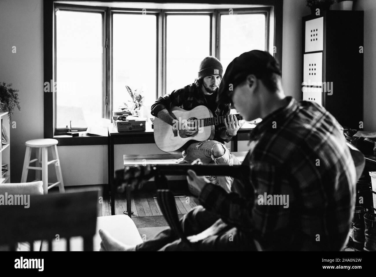 Brüder spielen zuhause zusammen Gitarre Stockfoto