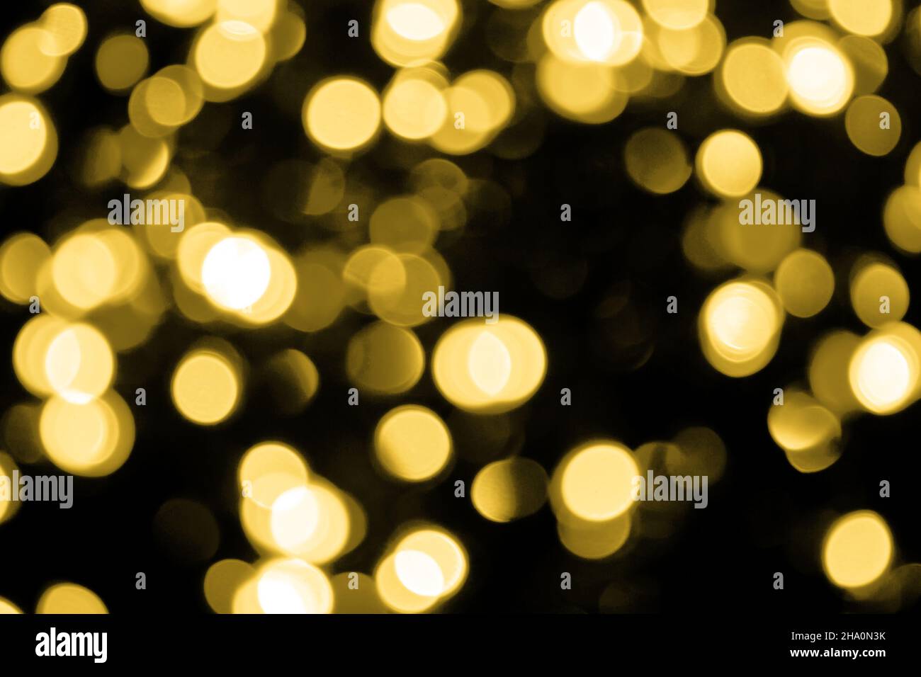 Unscharfsinnig Bokeh weihnachten große goldene Lichter auf schwarzem Hintergrund. Verschwommene abstrakte Gold-Glitzer-Textur. Gold Bokeh Glitter Tapete für Neujahr. Stockfoto