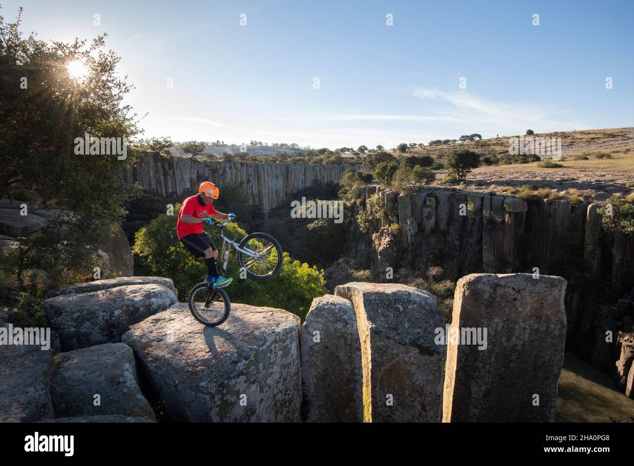 Ein Mann, der auf einem Canyon mit Hinterrad auf einem Trial Bike steht Stockfoto