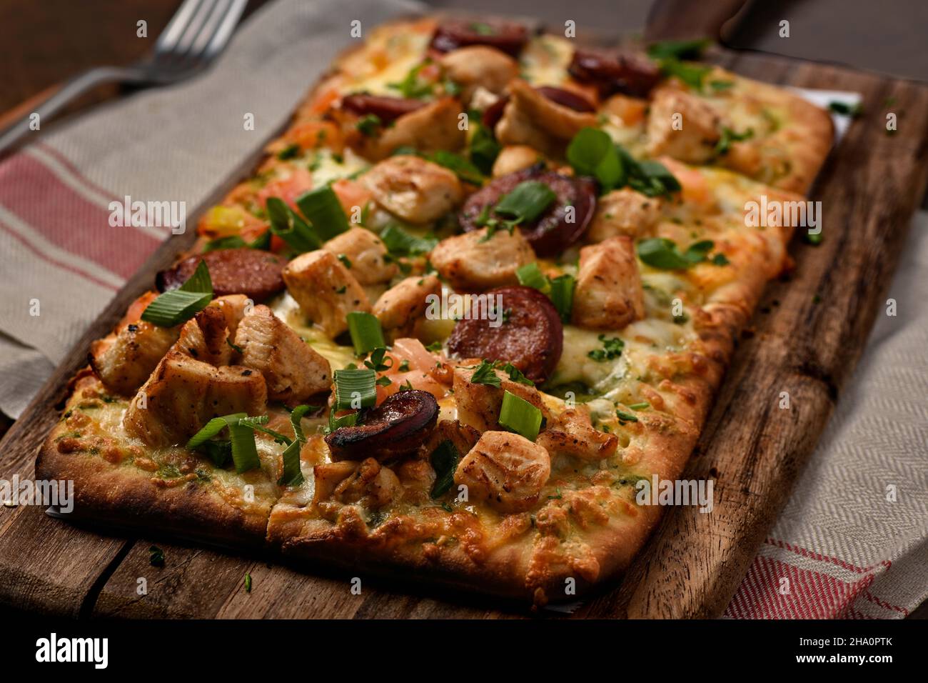 Rustikale Pizza über einem Stück Holz Stockfoto