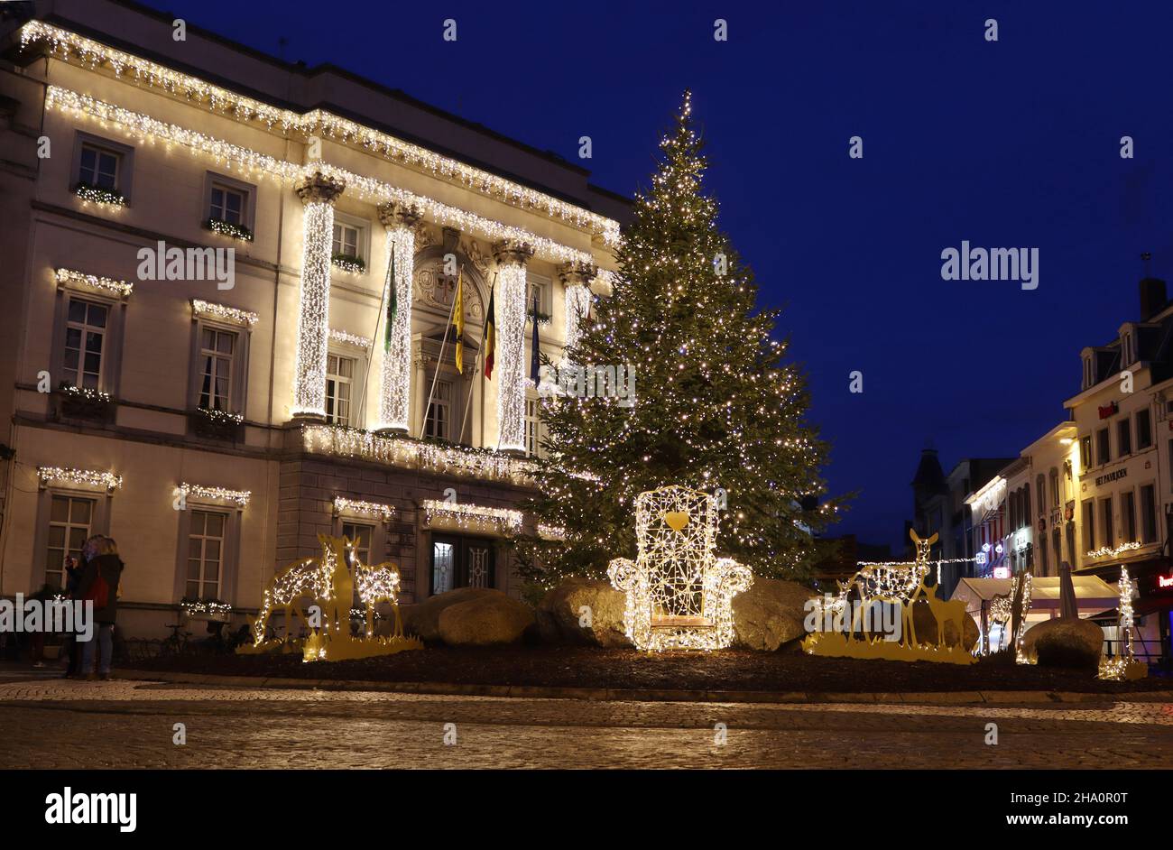 AALST, BELGIEN, 5. DEZEMBER 2021: Blick auf den Hauptplatz während der Weihnachtszeit, mit einem Weihnachtsbaum und dem beleuchteten alten Rathaus in Aalst. Stockfoto