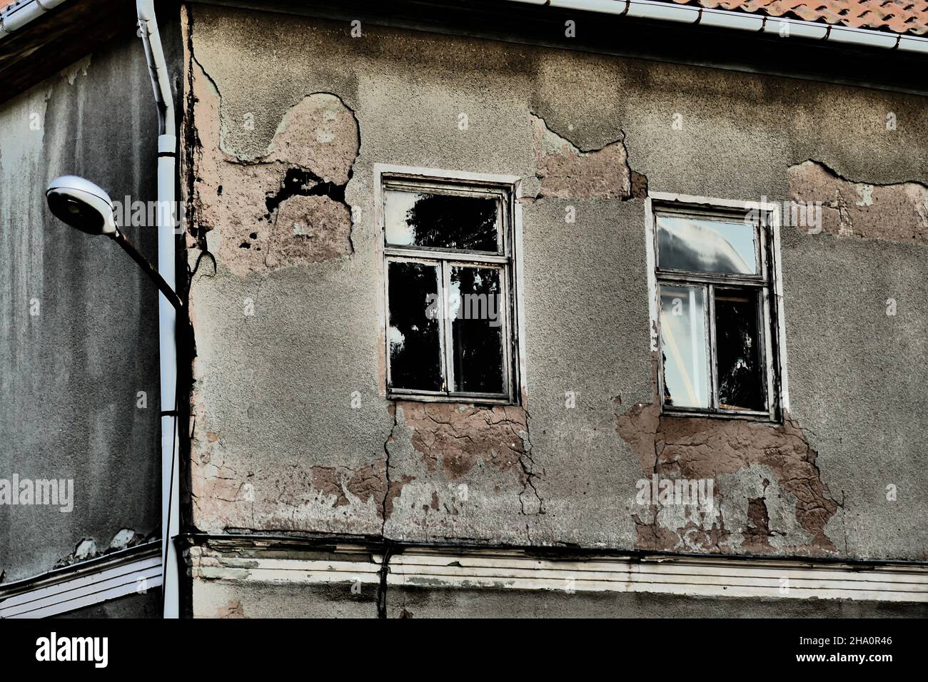 Alte Ecke eines Hauses mit zwei Fenstern und Lampe Stockfoto