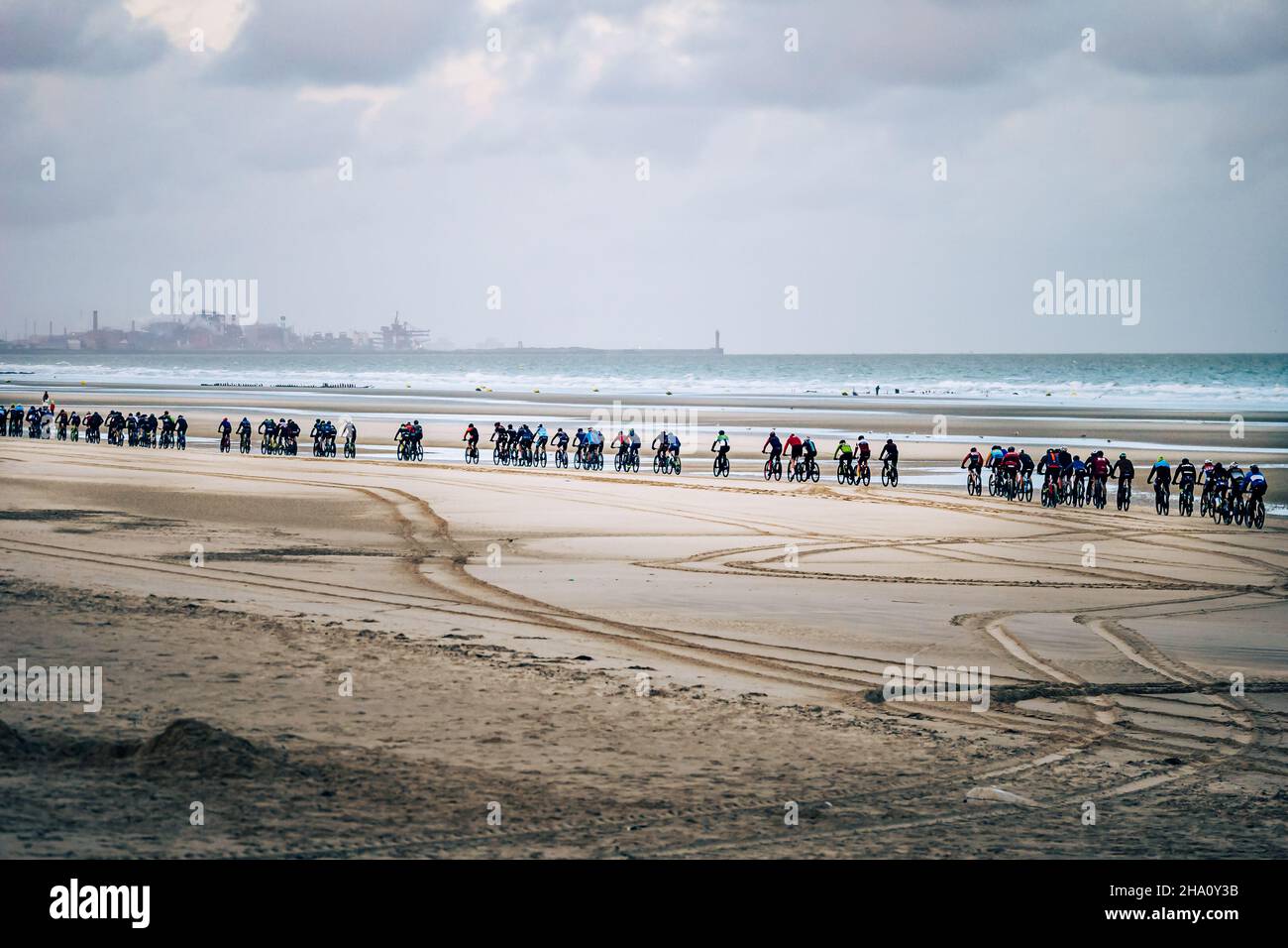 Menge von Rennfahrer beim Bike Race 'Beach Endurance' mit Dunkirk im Hintergrund Stockfoto