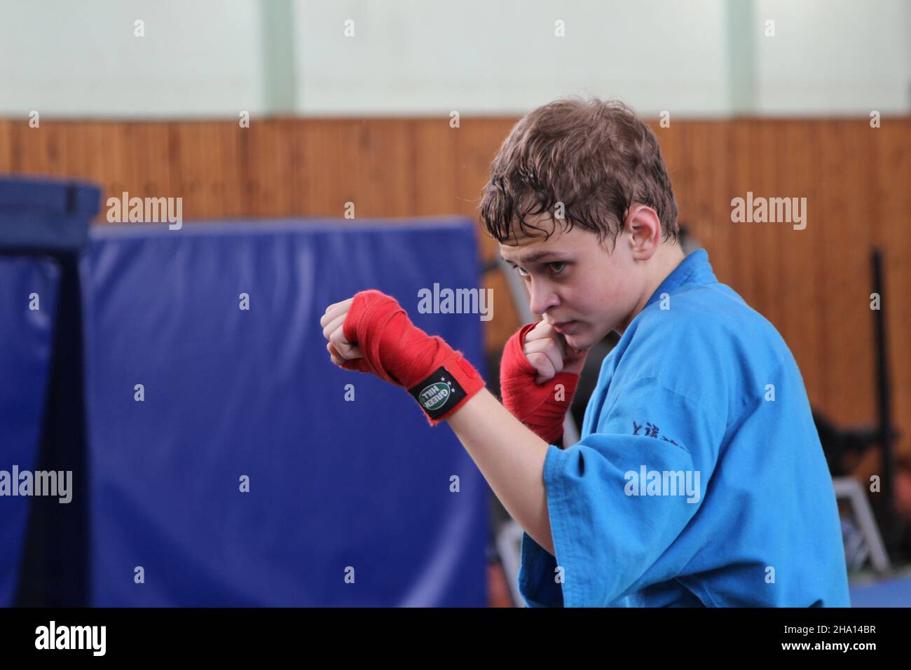 Kampfkunst Japan. Portrait eines jungen Mannes, in einem blauen Sport-Kimono in der Turnhalle, führt Übungen im Training. Stockfoto