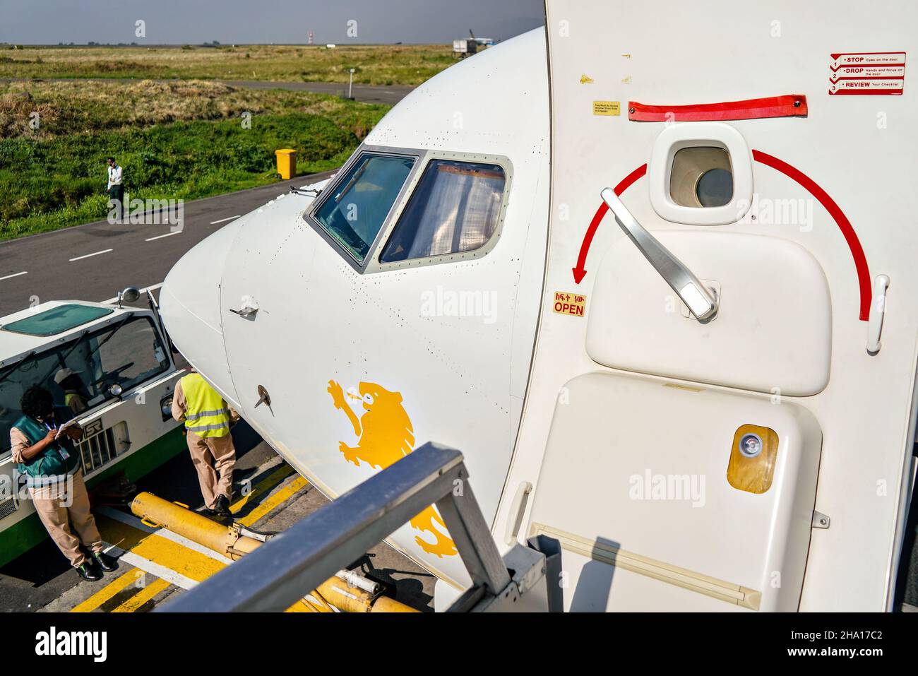 Addis Abeba, Äthiopien - 23. April 2019: Die Sonne scheint auf die geöffnete Tür eines Verkehrsflugzeugs, wie sie beim Einsteigen in das äthiopische Flugzeug zu sehen ist, am Boden perso Stockfoto