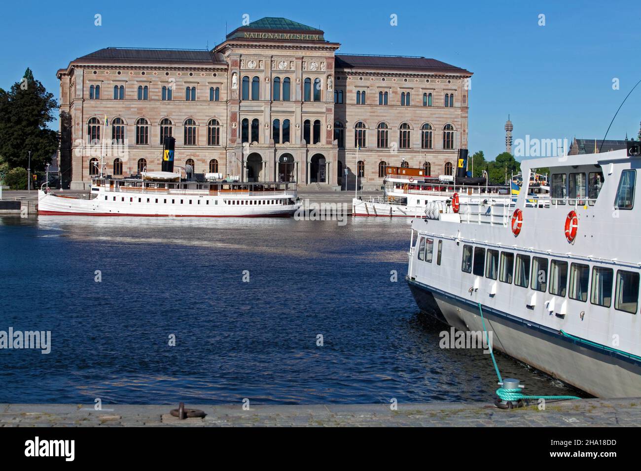 Stockholm, Schweden - 11. Juni 2020: Das Schwedische Nationalmuseum in Stockholm von der anderen Seite des Wassers mit Booten im Vordergrund und Kaknastower Stockfoto