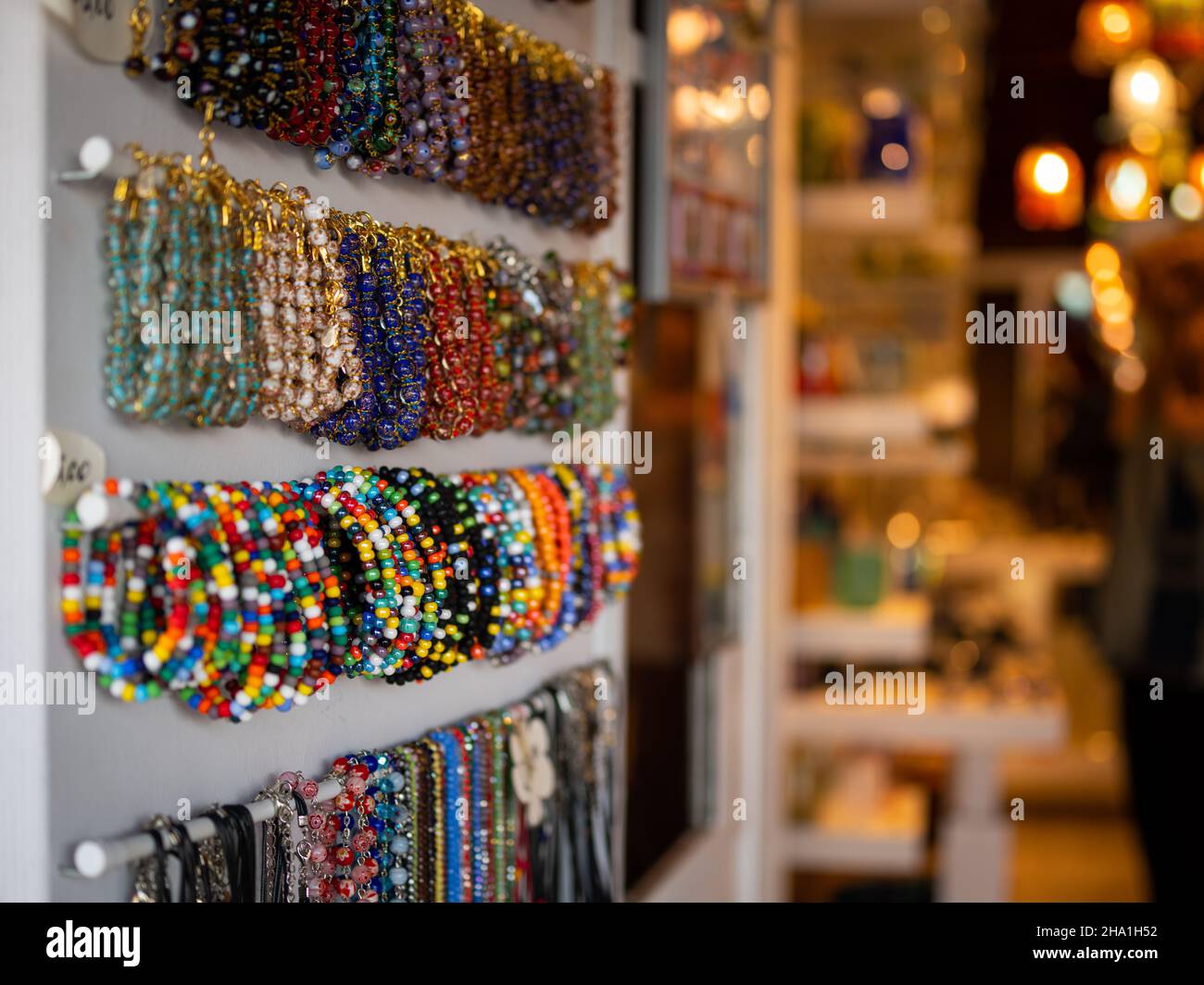 Armbänder aus Glas hängen am Netz eines kleinen Ladens in Murano (Venedig, Italien) Stockfoto