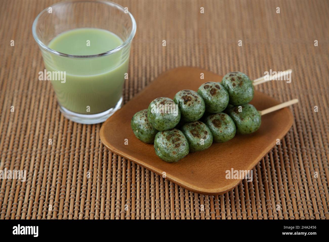 Dango Beifuß Knödel Reiskuchen Japanische Süßwaren Matcha grüner Milchtee isoliert auf dem Tisch Stockfoto