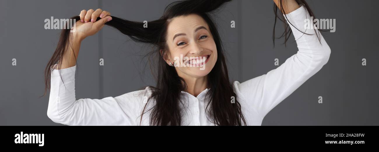 Porträt einer reifen Frau, die lachend ihre Haare aus der Nähe hält Stockfoto