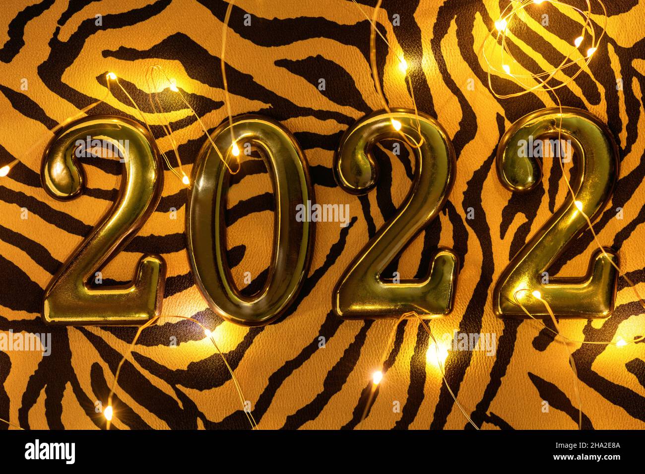Nummer 2022 auf Tiger-Tuch mit leuchtender Girlande, flaches Lay. Symbol 2022 Tiger Stockfoto