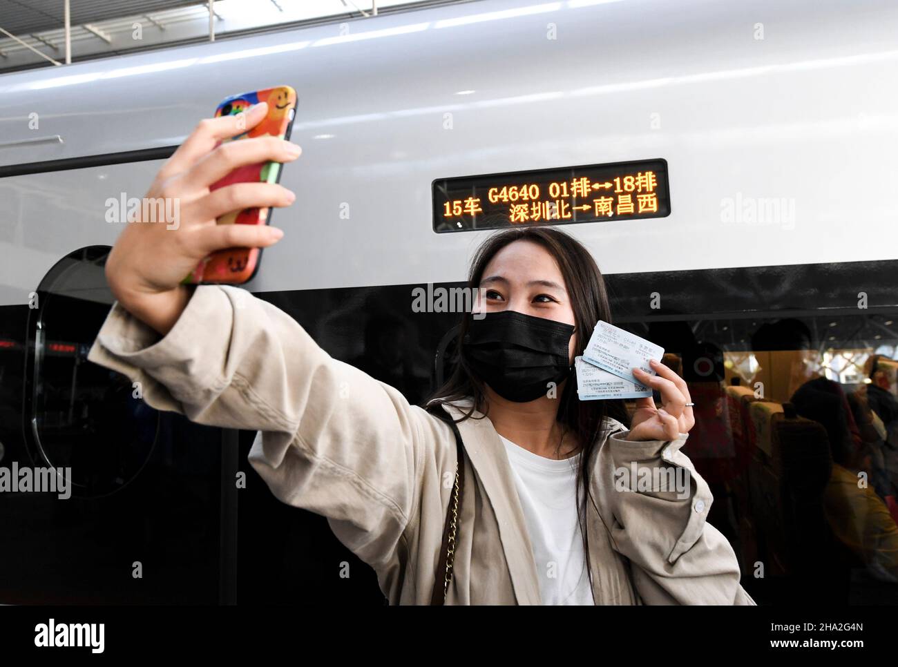 (211210) -- SHENZHEN, 10. Dezember 2021 (Xinhua) -- Ein Passagier nimmt Selfies vor einem Hochgeschwindigkeitszug auf, der nach Nanchang in der ostchinesischen Provinz Jiangxi am Nordbahnhof Shenzhen in Shenzhen, südchinesischer Provinz Guangdong, am 10. Dezember 2021 fährt. Eine neue Hochgeschwindigkeitsbahn, die die Stadt Ganzhou in der ostchinesischen Provinz Jiangxi mit der südlichen Metropole Shenzhen in der Provinz Guangdong verbindet, nahm am Freitag den offiziellen Betrieb auf. Quelle: Xinhua/Alamy Live News Stockfoto