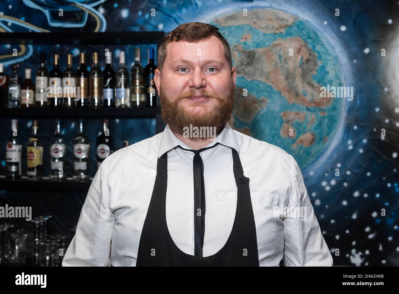 Bärtiger Erwachsener kaukasisch aussehender professioneller Barkeeper Porträt im Nachtclub. Stockfoto