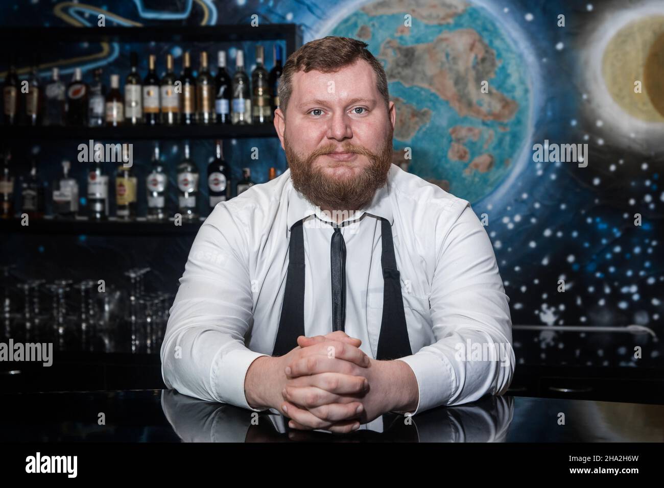 Bärtiger Erwachsener kaukasisch aussehender professioneller Barkeeper Porträt im Nachtclub. Stockfoto