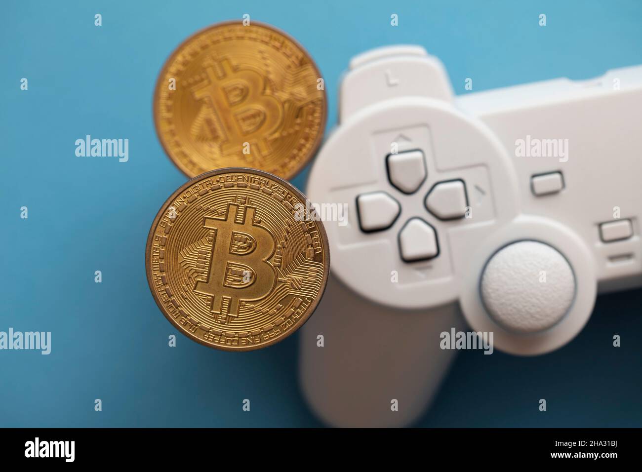 Krypto-Gaming-Konzept. Videospiel-Controller mit einer Bitcoin-Kryptowährung-Münze Stockfoto