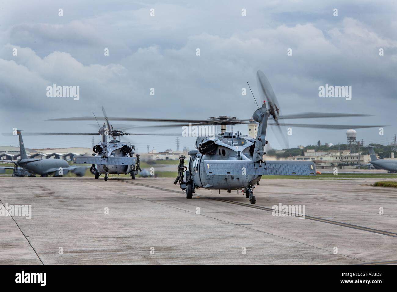 Zwei HH-60G Pave Hawks fahren mit dem Taxi über die Startbahn und bereiten sich auf den Start vor, um am jährlichen Turkey Shoot auf dem Kadena Air Base, Japan, am 29. November 2021 teilzunehmen. Der Turkey Shoot ist ein freundlicher, basisweiter Wettbewerb, der einmal im Jahr stattfindet und es Einheiten wie dem 33rd RQS ermöglicht, ihre Aufgaben in verschiedenen Szenarien zu erfüllen. (USA Luftwaffe Foto von Airman 1st Klasse Cesar J. Navarro) Stockfoto