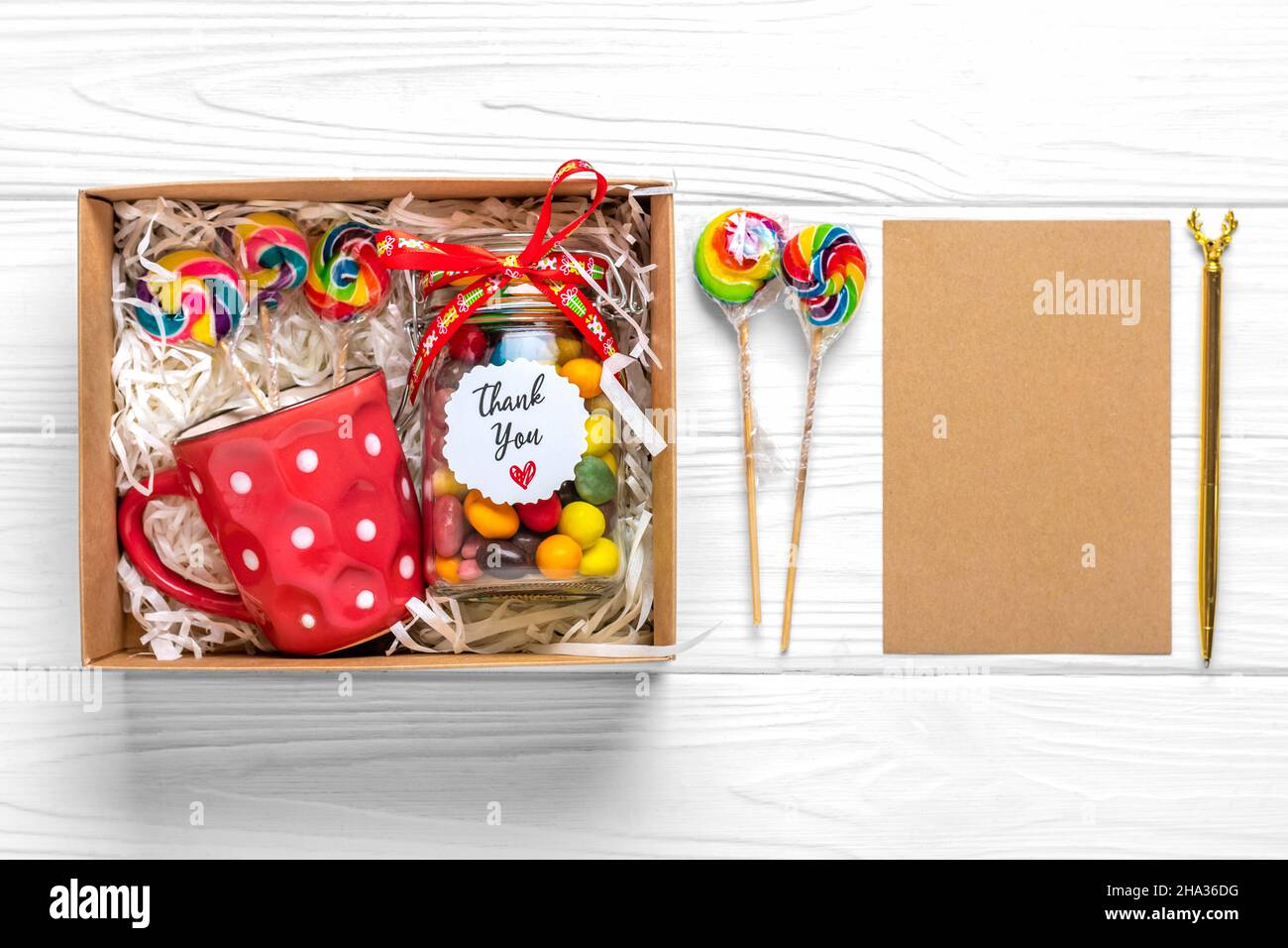 Handgemachtes Pflegepaket, saisonale Geschenkbox mit Süßigkeiten, Tasse auf weißem Tisch Personalisierter umweltfreundlicher Korb für Familie, Freunde, Mädchen für Danksagedanken Stockfoto