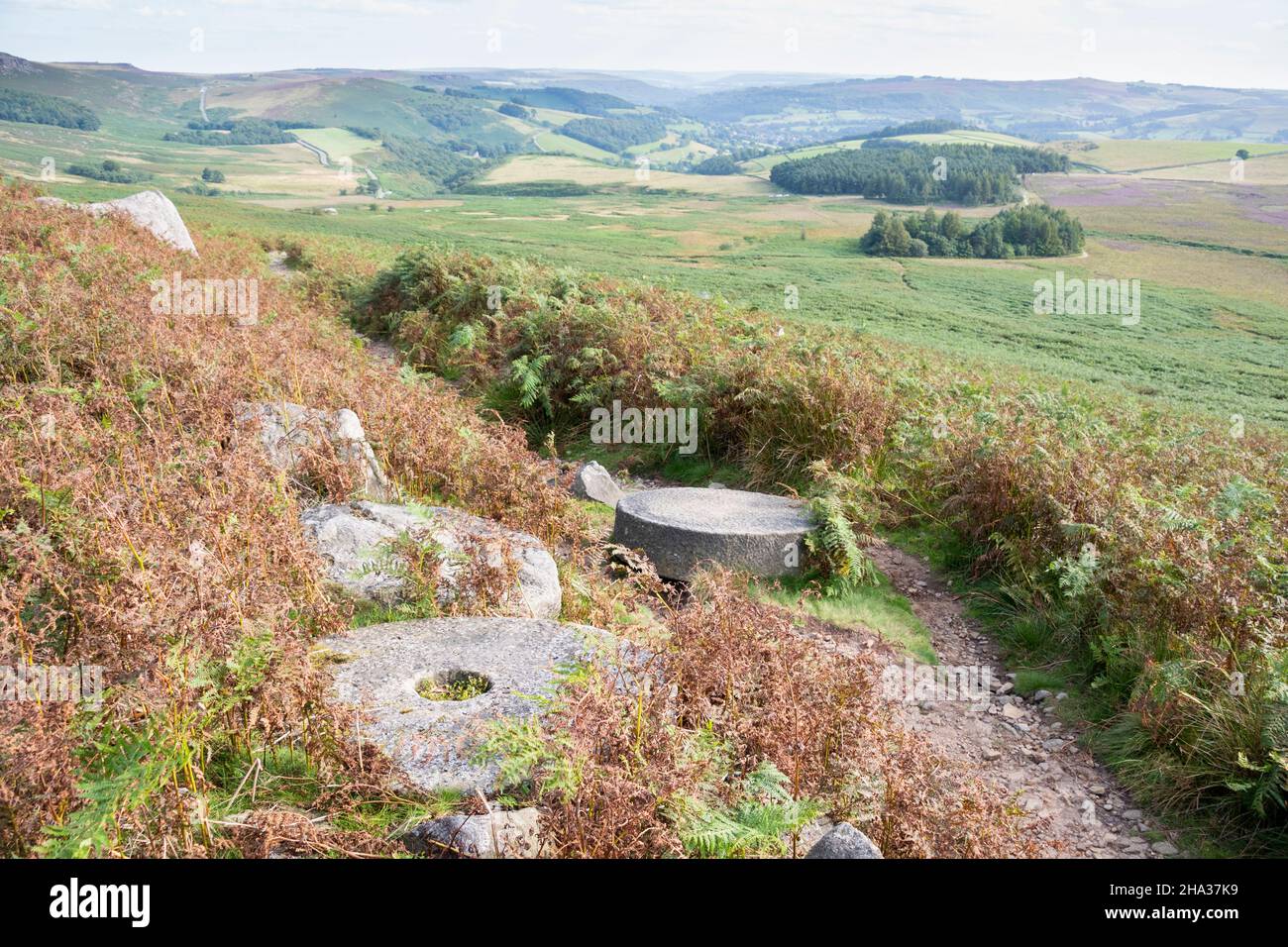 Verlassene Mühlsteine auf einem Hügel mit Blick auf die Moorlandschaft, Peak District, Großbritannien Stockfoto