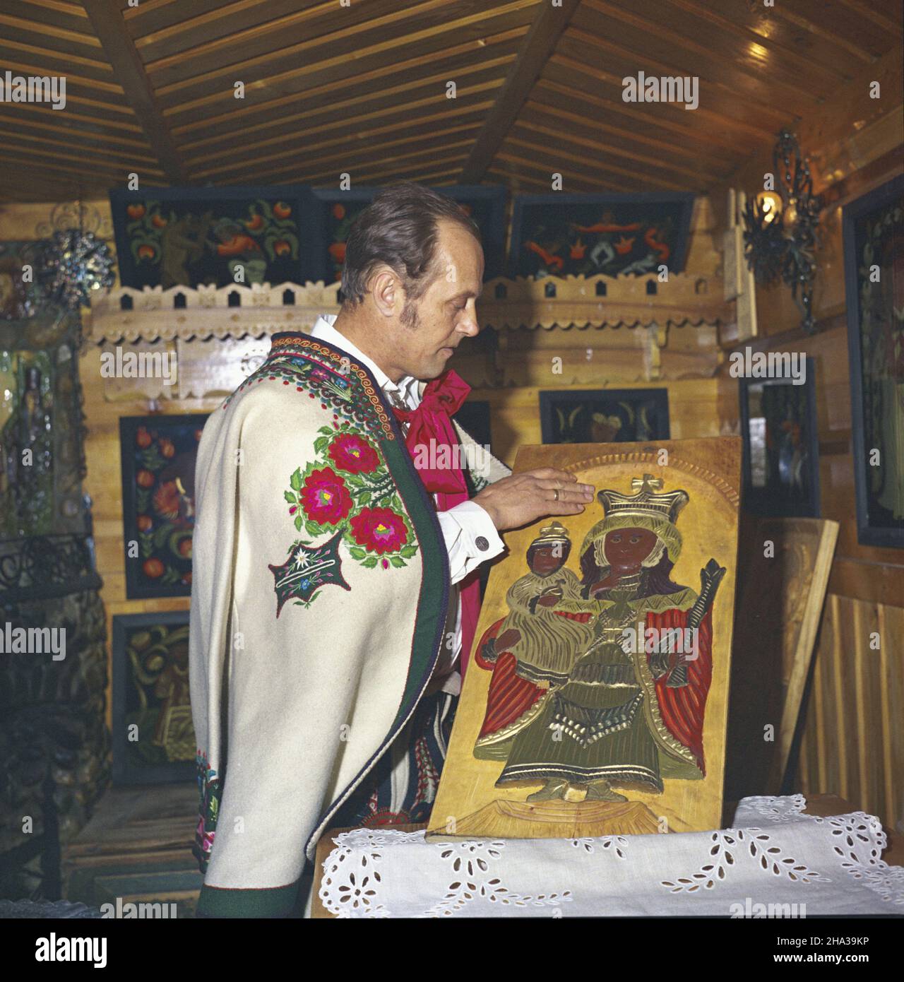 Zakopane 03,1980. W³adys³aw Walczak Baniecki artysta ludowy, malarz na szkle, rzeŸbiarz. Jego prace s¹ m.in. w Miêdzynarodowym Muzeum Sztuki Naiwnej w Rio de Janeiro. NZ. Malarz w pracowni przy ul. Koœcielskiej z p³askorzeŸb¹ w drewnie, przedstawiaj¹c¹ Madonnê z Dzieci¹tkiem. Artysta ubrany jest w tzw. cuchê (czuha, gunia), kurtê z we³nianego, samodzia³owego sukna, ozdobion¹ haftem i obszyciami. mw PAP/Stanis³aw Momot Dok³adny dzieñ wydarzenia nieustalony. Zakopane, März 1980. Zakopane, März 1980. Glasmaler und Bildhauer Wladyslaw Walczak Baniecki in seinem Atelier in Kosc Stockfoto