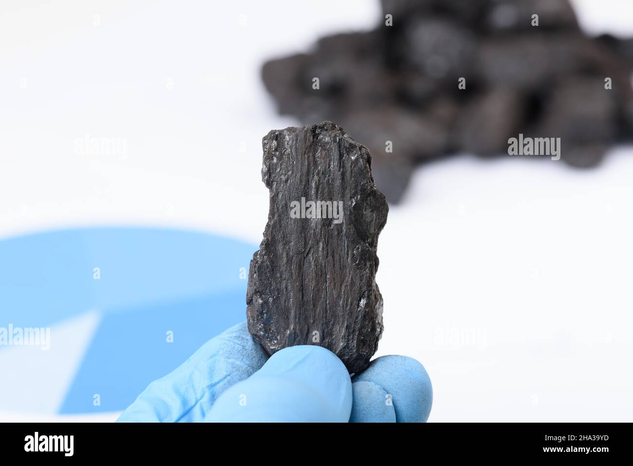 Kohleklumpen in der Hand des Wissenschaftlers. Laborkohlenanalyse, fossile Brennstoffe Forschung. Stockfoto