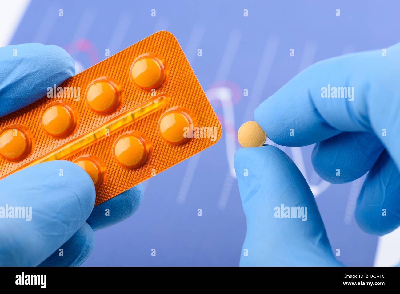 Wissenschaftler halten eine kleine Pille in der einen Hand und eine Blisterpackung in der anderen Stockfoto