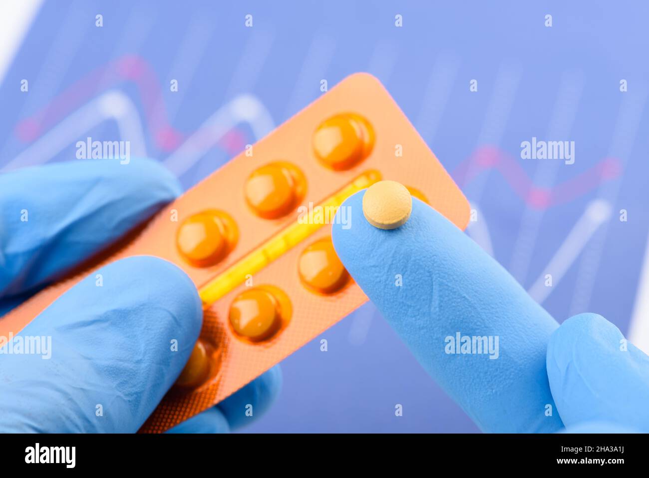 Wissenschaftler halten kleine Pille auf der Fingerspitze einer Hand und Blisterpackung in der anderen. Neue medizinische Behandlung oder Ergänzung der wissenschaftlichen Laborforschung. Stockfoto