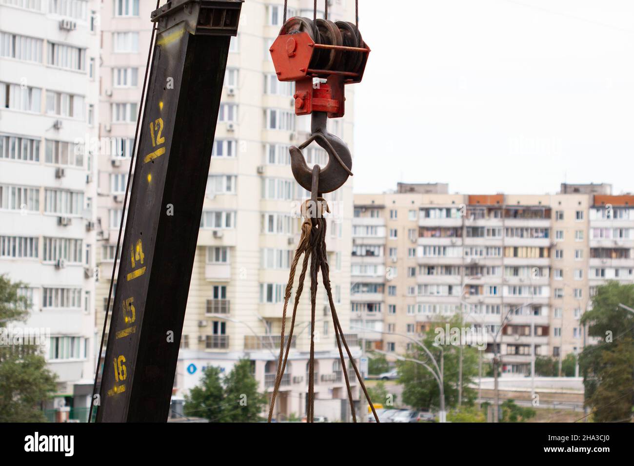 Kranhaken. Turm Kranich-Hoist-Seil gegen den blauen Himmel und neues Gebäude. Ein Geißel der Winde. Kranzugseile. Baustelle. Baugewerbe Stockfoto