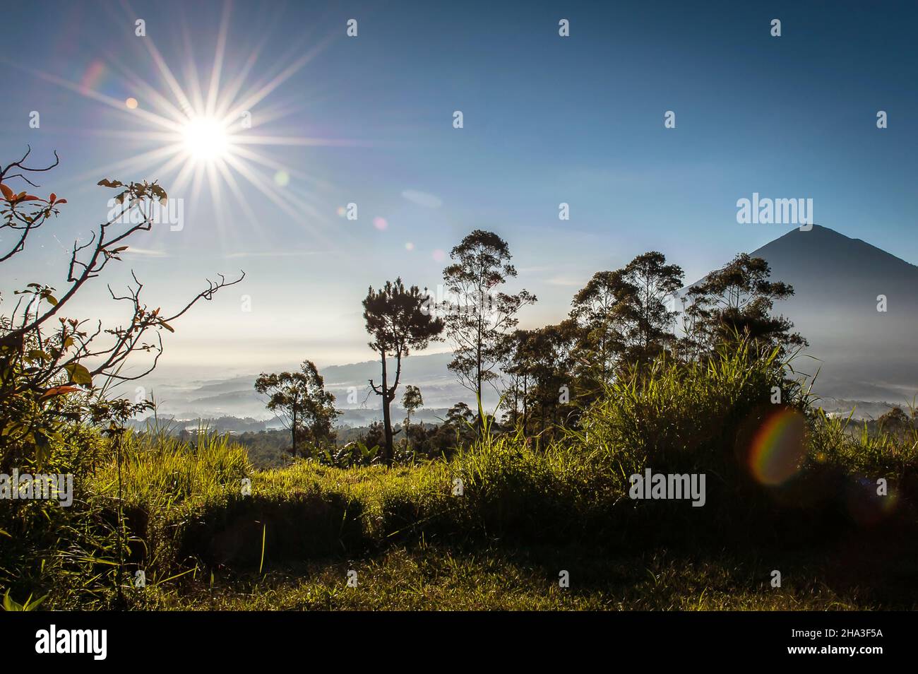 Sonne scheint wie ein Stern und Berggipfel in der Ferne. Stockfoto