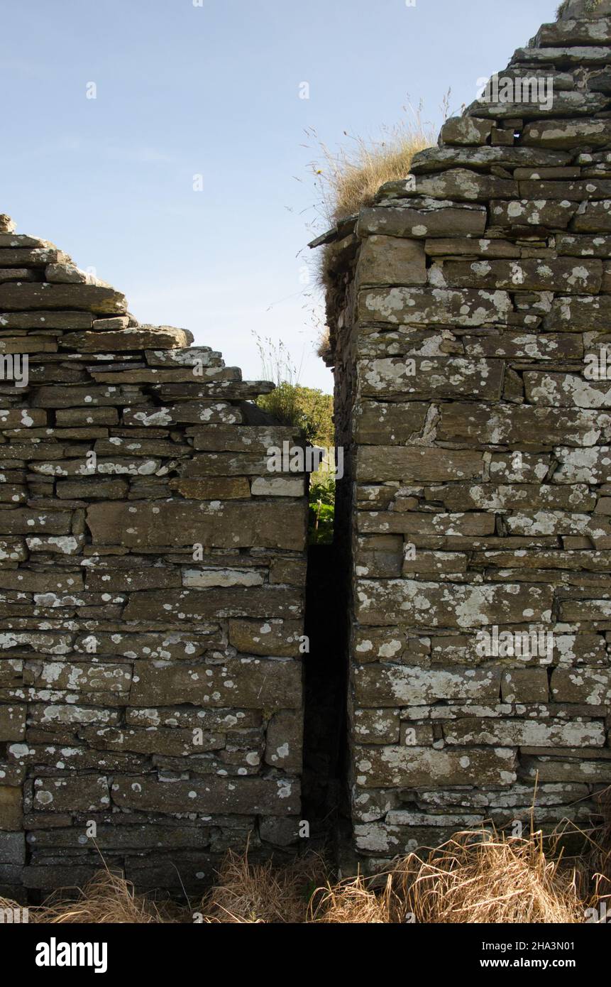 Zwei alte, aus Stein gestapelte Gebäude, die sich in Orkney, Schottland, in unmittelbarer Nähe befinden. Stockfoto