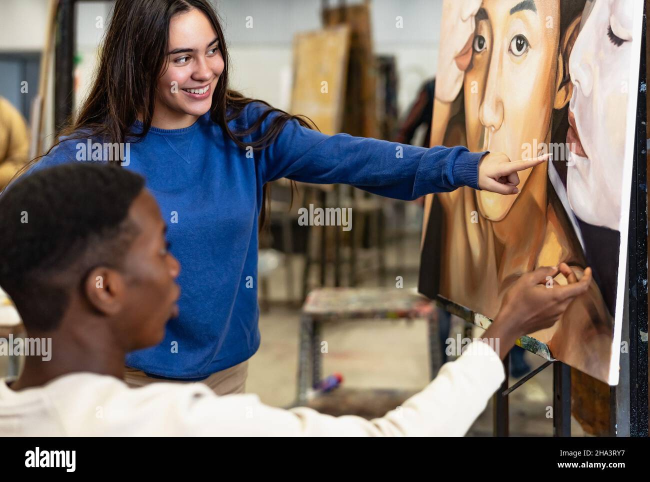 Junge multirassische Studenten lernen über Malerei auf Leinwand während der Lektion in der Fakultät der Künste Universität - Bildung und Kultur Konzept Stockfoto
