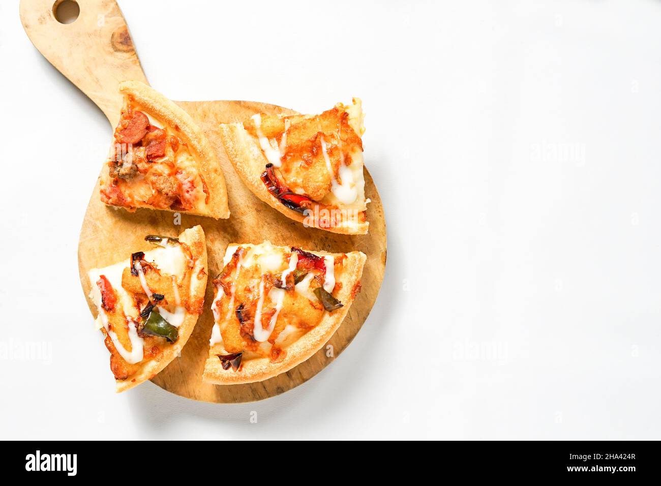 Vier Scheiben Pizza auf dem hölzernen Paddel oder Schale und ein Stapel Toast Weißbrot. Die westlichen Lebensmittel isoliert auf schwarz. Stockfoto