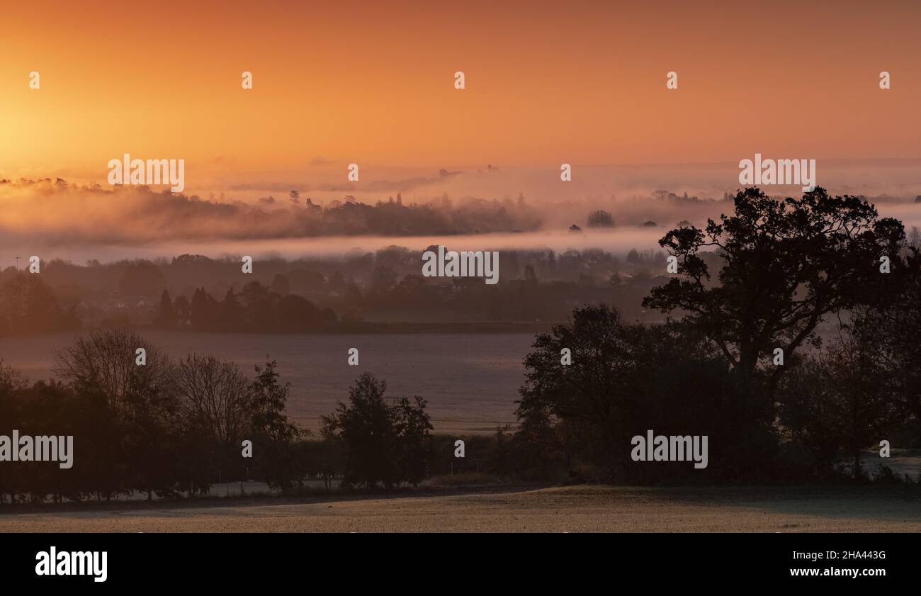 Wintersonnengang mit Schloss Windsor, das am Horizont aus dem Nebel auftaucht Stockfoto