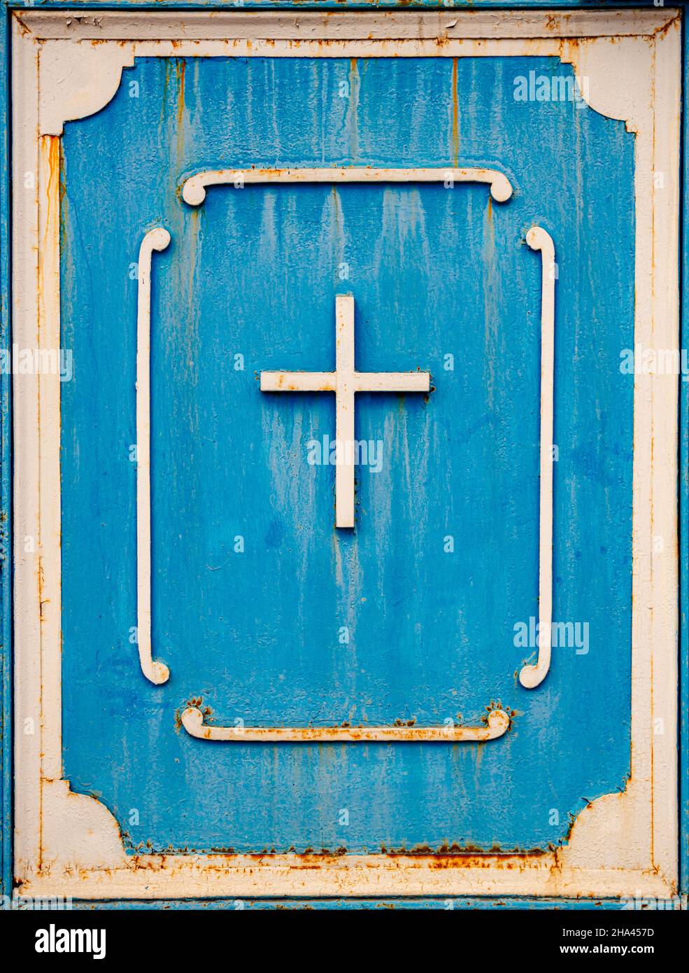 Altes Metallkreuz auf blauer Tür christian Symbol Stockfoto