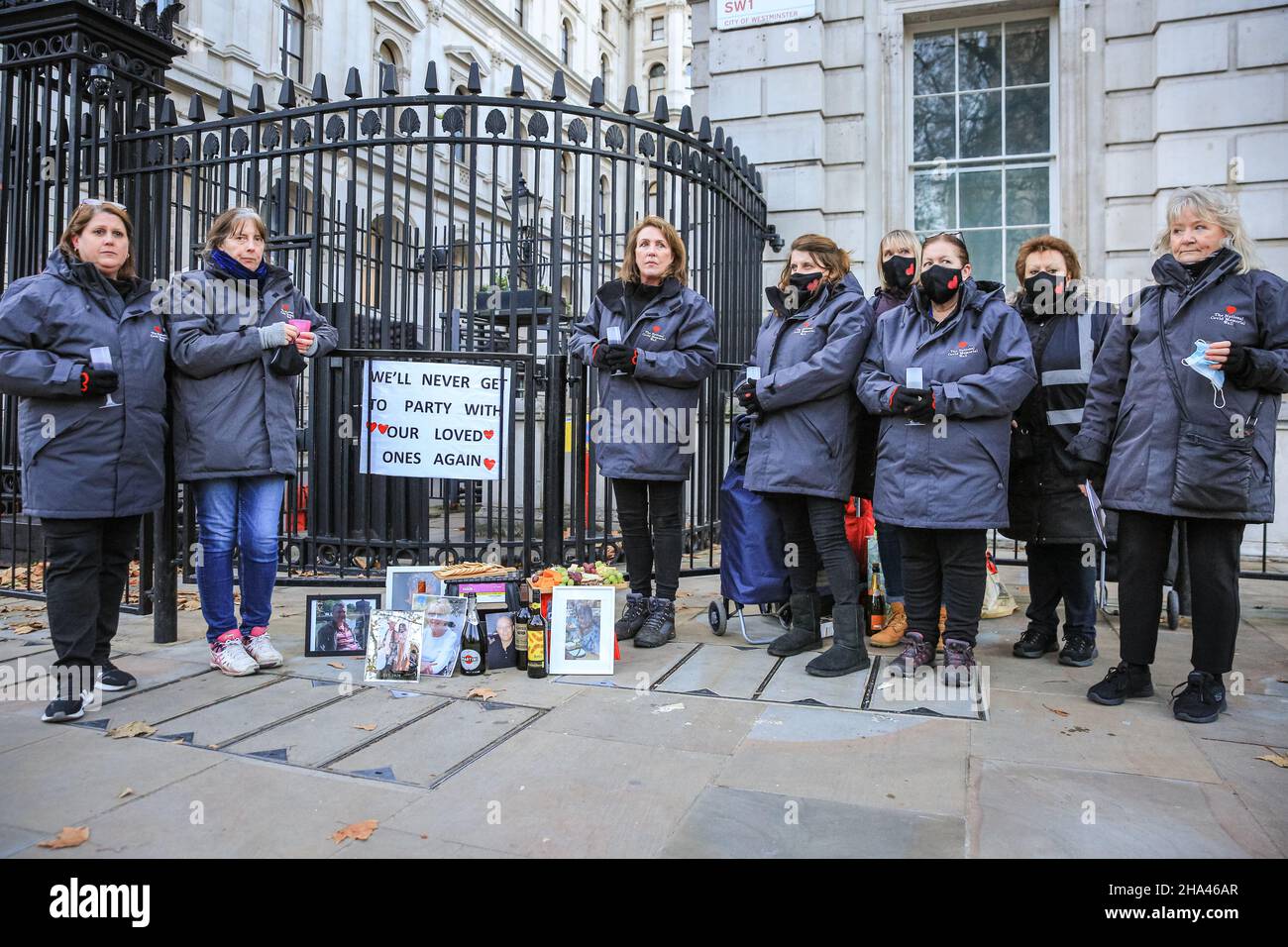 Westminster, London, Großbritannien. 10th Dez 2021. Eine Gruppe von Frauen von „Covid-19 Hinterbliebene Familien für Gerechtigkeit“ protestiert vor den Toren der Downing Street mit Käse und Wein gegen die angebliche Weihnachtsfeier, die letztes Weihnachten mit Käse und Wein in der Downing Street stattgefunden haben könnte. Die Frauen, alle ehrenamtlich an der National Covid Memorial Wall, haben Bilder von Angehörigen mitgebracht, die an Covid gestorben sind, und sind auch da, um die Regierung ihrer Ansicht nach an die vielen Menschen zu erinnern, die unnötig starben. Kredit: Imageplotter/Alamy Live Nachrichten Stockfoto