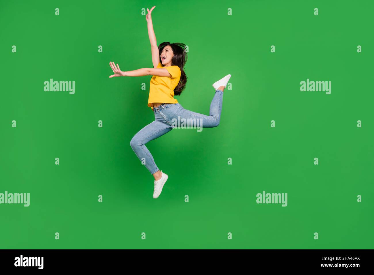 In voller Länge Foto von attraktiven jungen Frau springen bis suchen leeren Raum Tanz Ballerina isoliert auf grünem Hintergrund Stockfoto