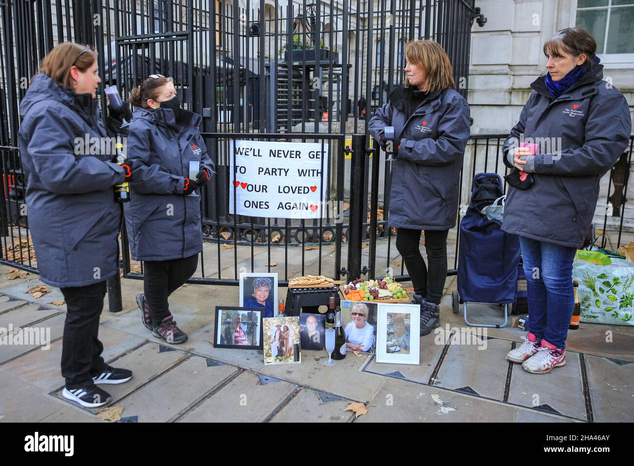 Westminster, London, Großbritannien. 10th Dez 2021. Eine Gruppe von Frauen von „Covid-19 Hinterbliebene Familien für Gerechtigkeit“ protestiert vor den Toren der Downing Street mit Käse und Wein gegen die angebliche Weihnachtsfeier, die letztes Weihnachten mit Käse und Wein in der Downing Street stattgefunden haben könnte. Die Frauen, alle ehrenamtlich an der National Covid Memorial Wall, haben Bilder von Angehörigen mitgebracht, die an Covid gestorben sind, und sind auch da, um die Regierung ihrer Ansicht nach an die vielen Menschen zu erinnern, die unnötig starben. Kredit: Imageplotter/Alamy Live Nachrichten Stockfoto