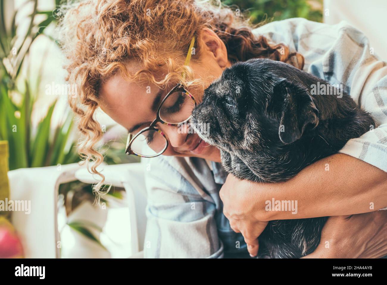 Glückliche Frau mit ihrem besten Freund Hund Mops in zärtlich Freizeit Aktivität zusammen zu Hause. Liebe Menschen und Tiere Lifestyle-Konzept. Erwachsene Frau mit Hund Freundschaft Stockfoto