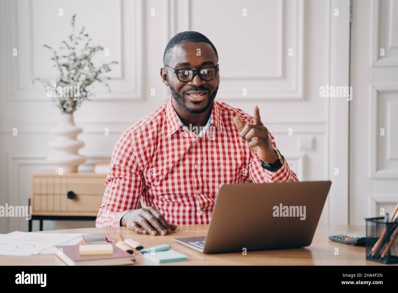 Fröhlicher afro-amerikanischer männlicher Englischlehrer, der Fernunterricht online hat Stockfoto
