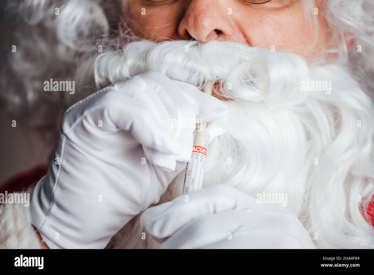 Santa spuckt salziges Wasser im Rahmen des PCR-Tests in den Behälter Stockfoto
