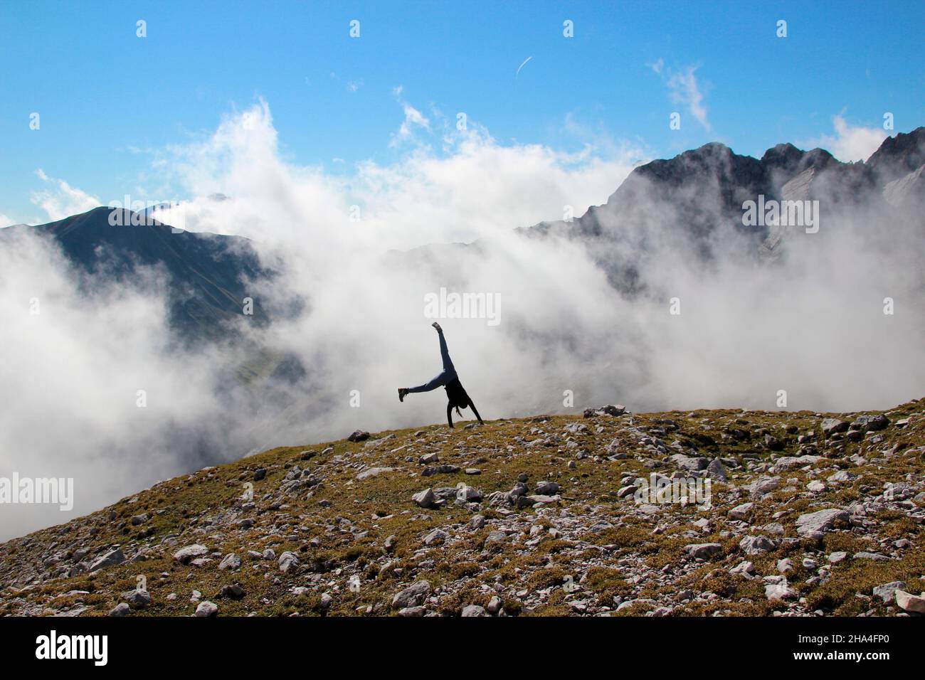 Junge Frau schlägt ein Fahrrad während der Wanderung zur zugspitze 2962 m,Nebel,wettersteingebirge garmisch-partenkirchen,oberbayern,bayern,süddeutschland,deutschland,europa, Stockfoto