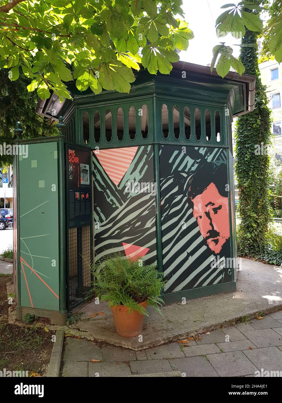 'The Pissoir', gusseisernes Achteck aus dem Jahr 1900. Street-Art-Projekt des Künstlers martin arz. Seit 2020 schmücken drei Persönlichkeiten die Fassade des denkmalgeschützten Nebenhauses: albert einstein, freddie Mercury, rainer-werner fassbinder. Alle drei lebten vorübergehend in münchen. Stockfoto