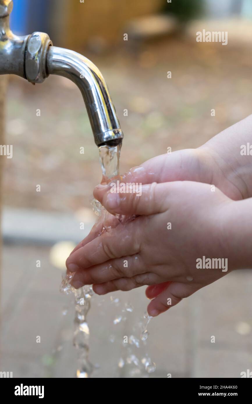 Hände mit einem Wasserhahn waschen Stockfoto