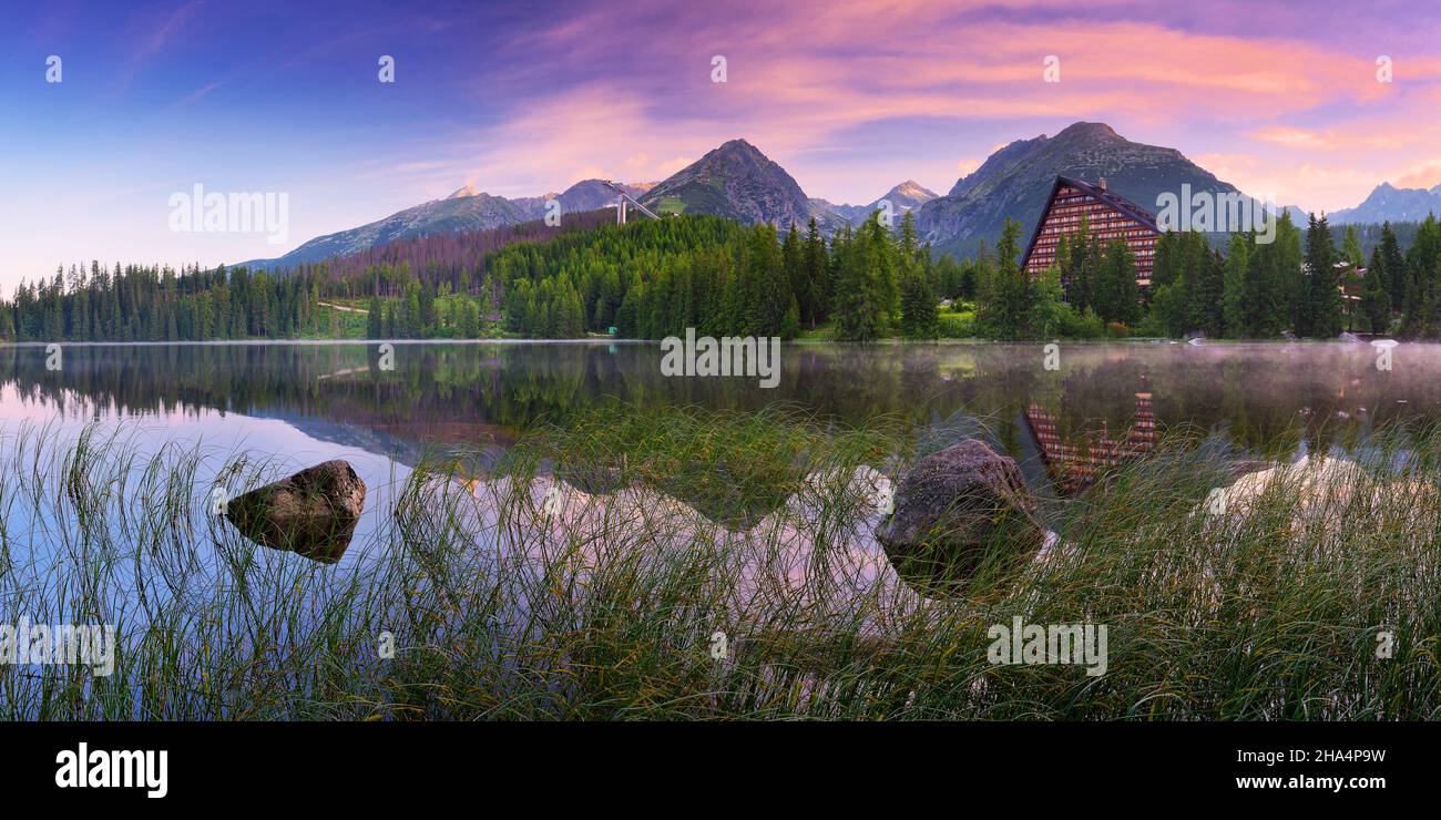 Bergpanorama mit buntem Sonnenaufgang über einem See Stockfoto