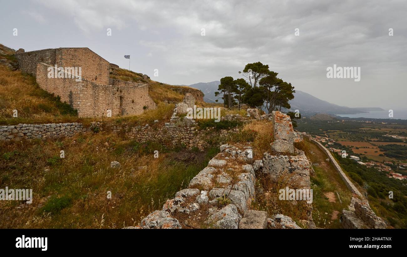 griechenland,griechische Inseln,ionische Inseln,kefalonia,agios georgios Burgkomplex,byzantinisch,16th. Jahrhundert,Hauptstadt kefalonia bis 1757,bewölktes Wetter,düstere Stimmung,Blick über die Festungsmauern in Richtung Südwesten,Bäume auf der Festungsmauer,die griechische Nationalflagge weht über den oberen linken Ruinen Stockfoto