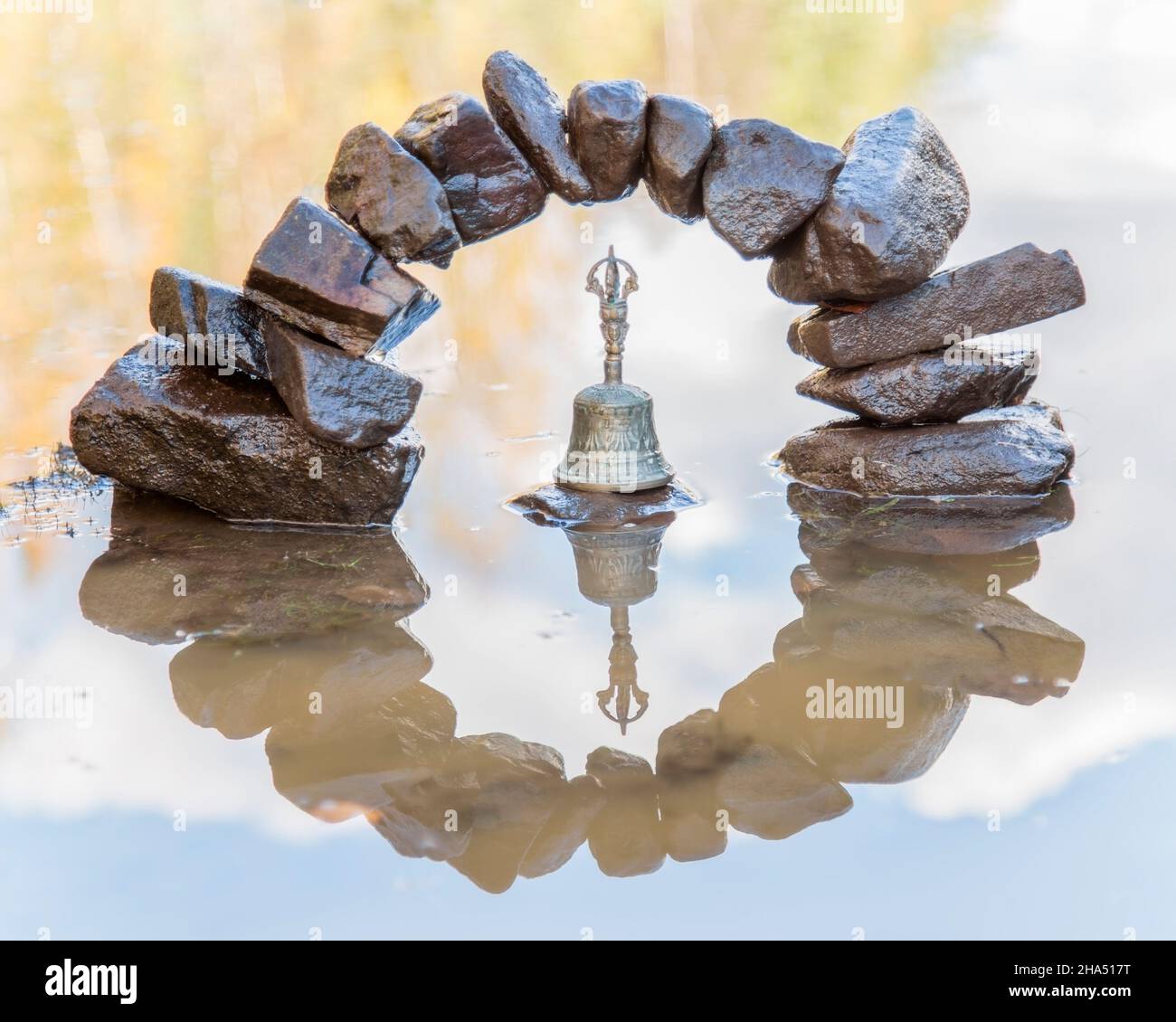 Die Felsen stapelten sich in einem Halbkreis, der sich im Wasser spiegelte und wie eine Null mit einer Glocke in der Mitte aussichtete Stockfoto