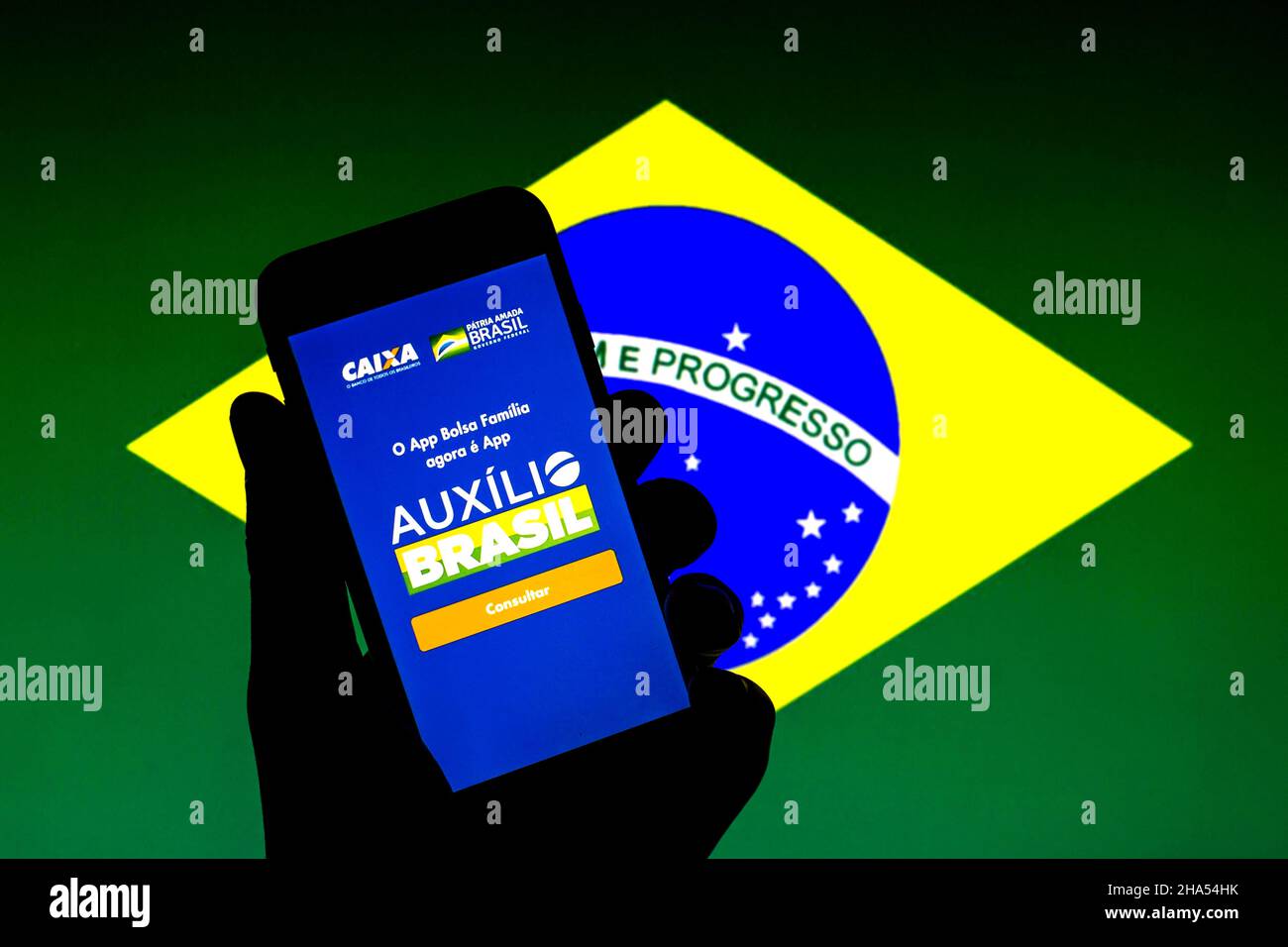 Barcelona, Katalonien, Spanien. 9th Dez 2021. In dieser Abbildung wird eine Auxilio Brasil App auf einem Smartphone mit einer brasilianischen Flagge im Hintergrund angezeigt. (Bild: © Thiago Prudencio/DAX via ZUMA Press Wire) Stockfoto