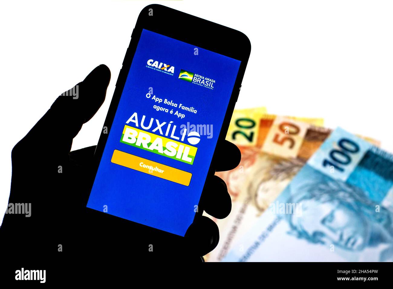 Barcelona, Katalonien, Spanien. 9th Dez 2021. In dieser Abbildung ist eine Auxilio Brasil App auf einem Smartphone mit einer brasilianischen echten Notizen im Hintergrund zu sehen. (Bild: © Thiago Prudencio/DAX via ZUMA Press Wire) Stockfoto