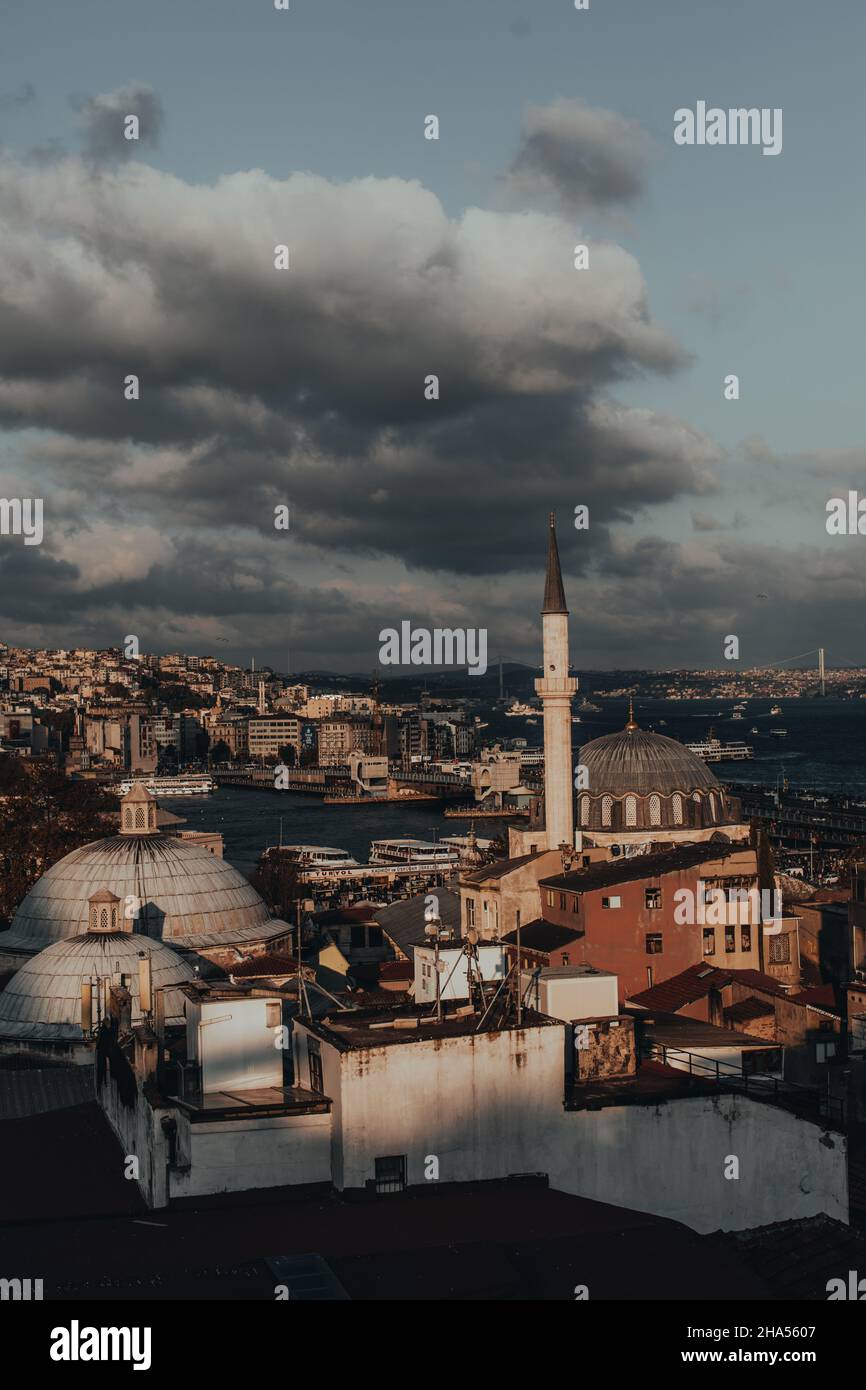 Wunderschöner Panoramablick mit dunklem bewölktem Himmel und alten türkischen Gebäuden in Istanbul. Vertikales Poster Stockfoto