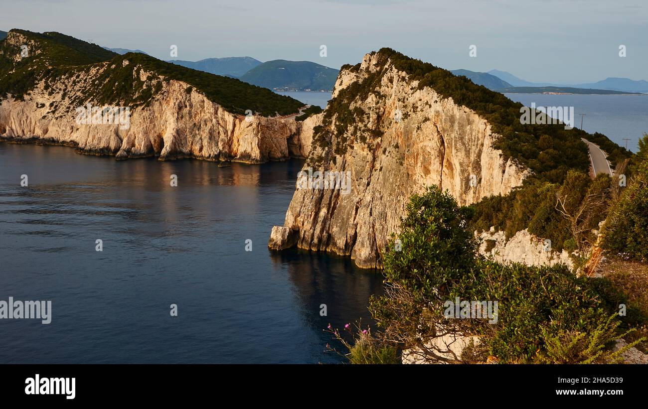 griechenland, griechische Inseln, ionische Inseln, Lefakada oder lefkas, Südspitze der Insel, steile Küste, Kap Lefkadas, Nachmittagslicht, Blick vom Leuchtturm zurück nach Norden, steiler Fels, grün, dunkles Wasser, blauer Himmel Stockfoto